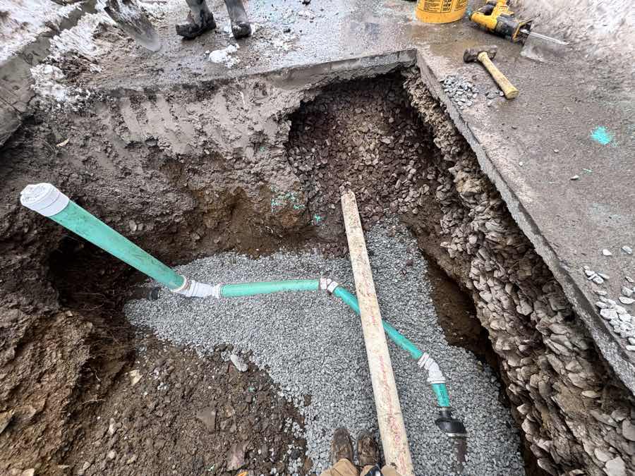 Sewer service pipe laid on crushed-stone bedding